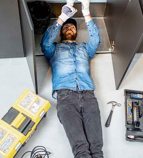 Professional plumber performing sink repair with tools by L.F. Fenimore Plumbing and HVAC in South New Jersey.