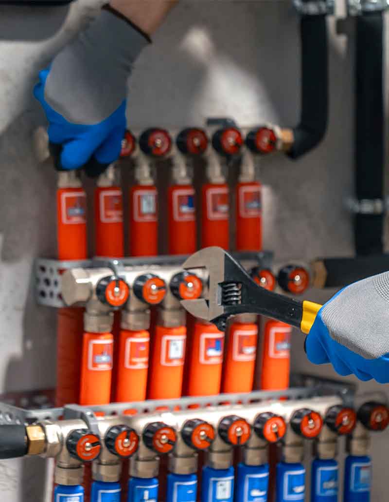 Professional plumber from L.F. Fenimore Plumbing and HVAC adjusting heating valves in South Jersey