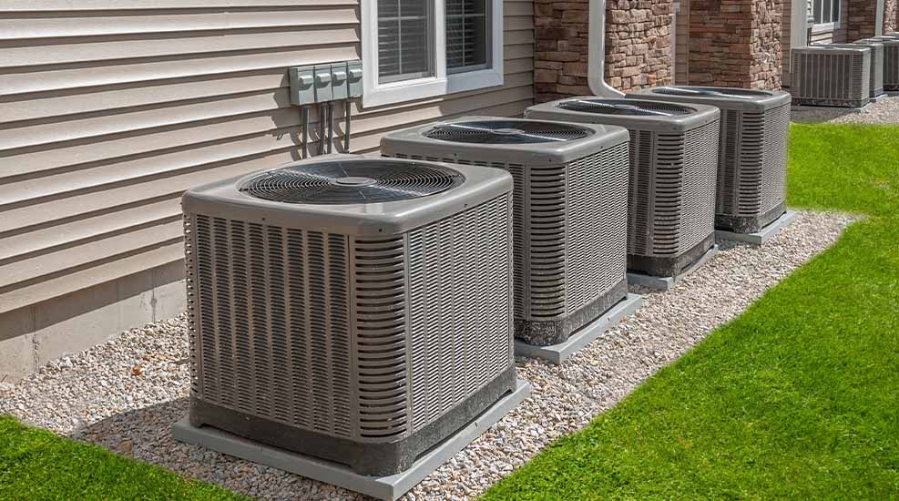 Row of outdoor HVAC condenser units installed alongside a residential building in South Jersey.
